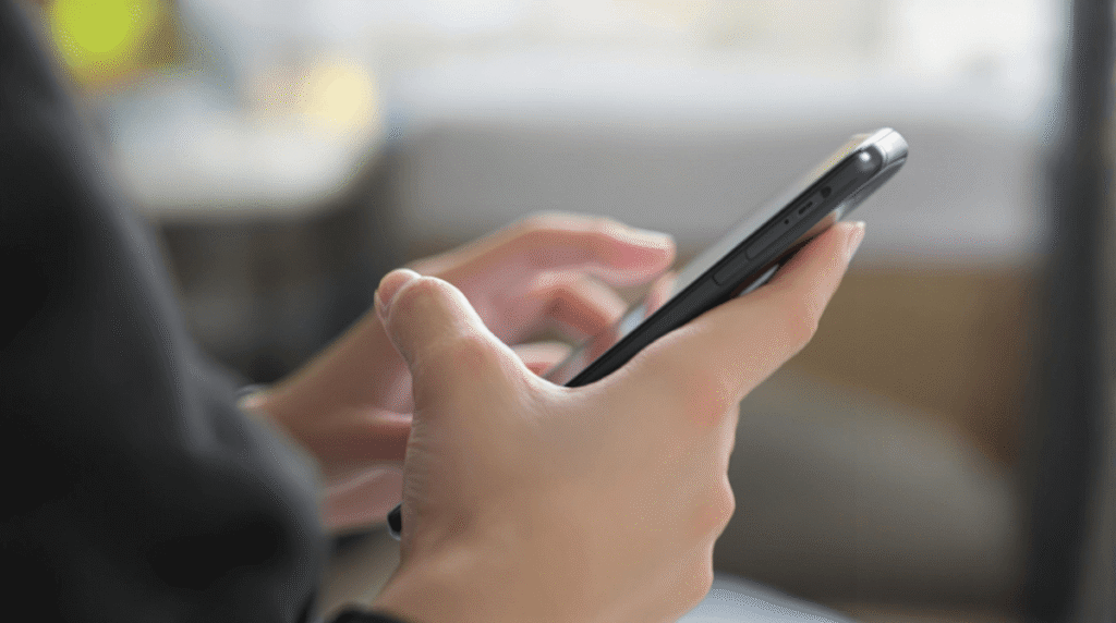横から見た女性がスマートフォンを操作しているイメージ